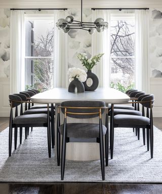 Neutral dining room with dining table and upholstered chair and pendant light and wallpaper