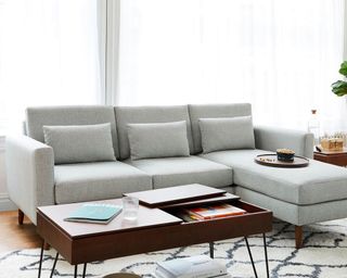 Gray sofa in living room, rug and wooden side table