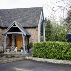 front garden with hedge hiding wheelie bin