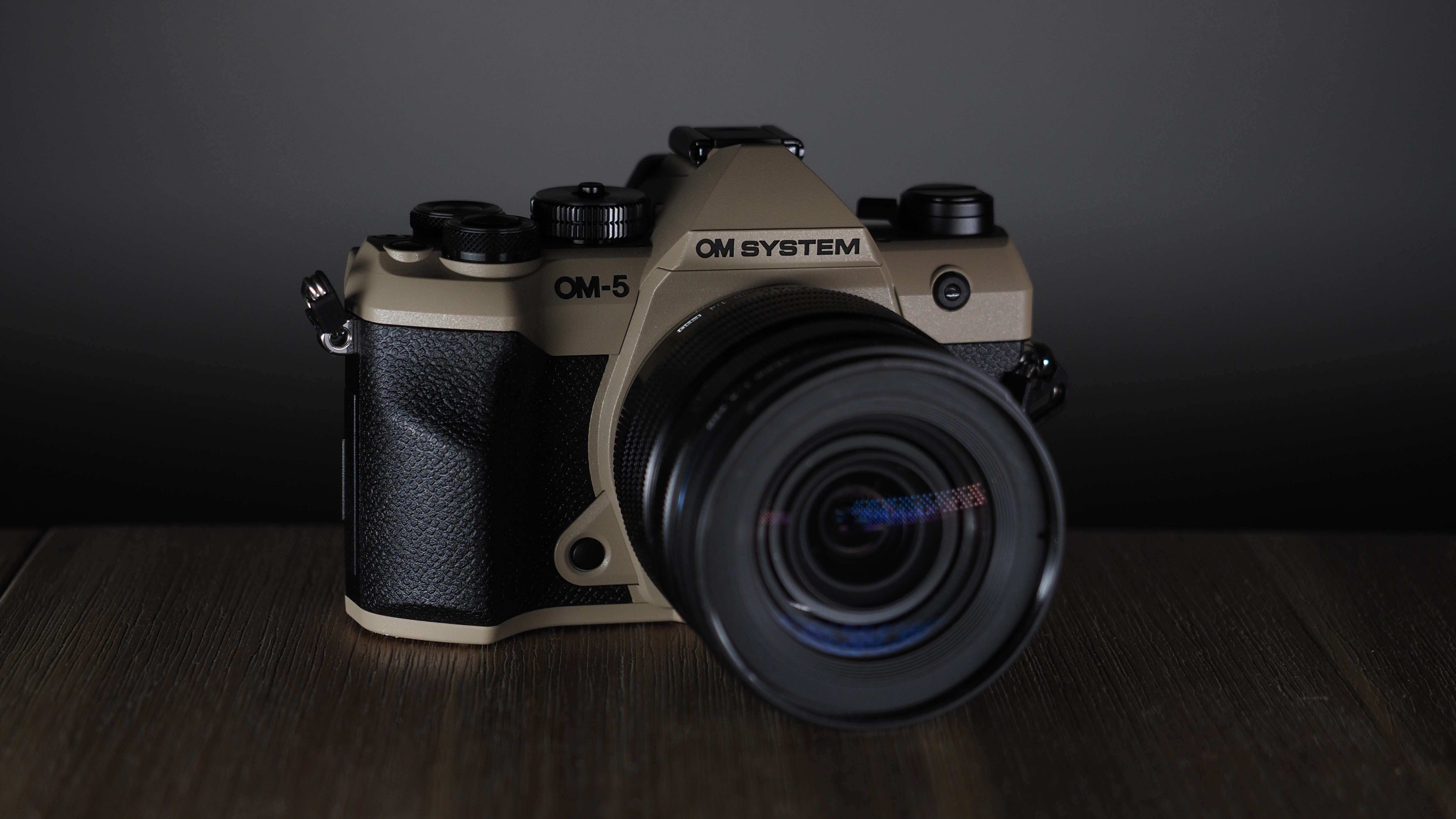OM System OM-5 Mark II on a wooden surface with an Olympus M.Zuiko 12-45mm lens