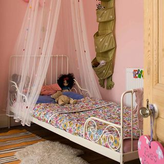 chidren bedroom with pink wall white bed with curtains