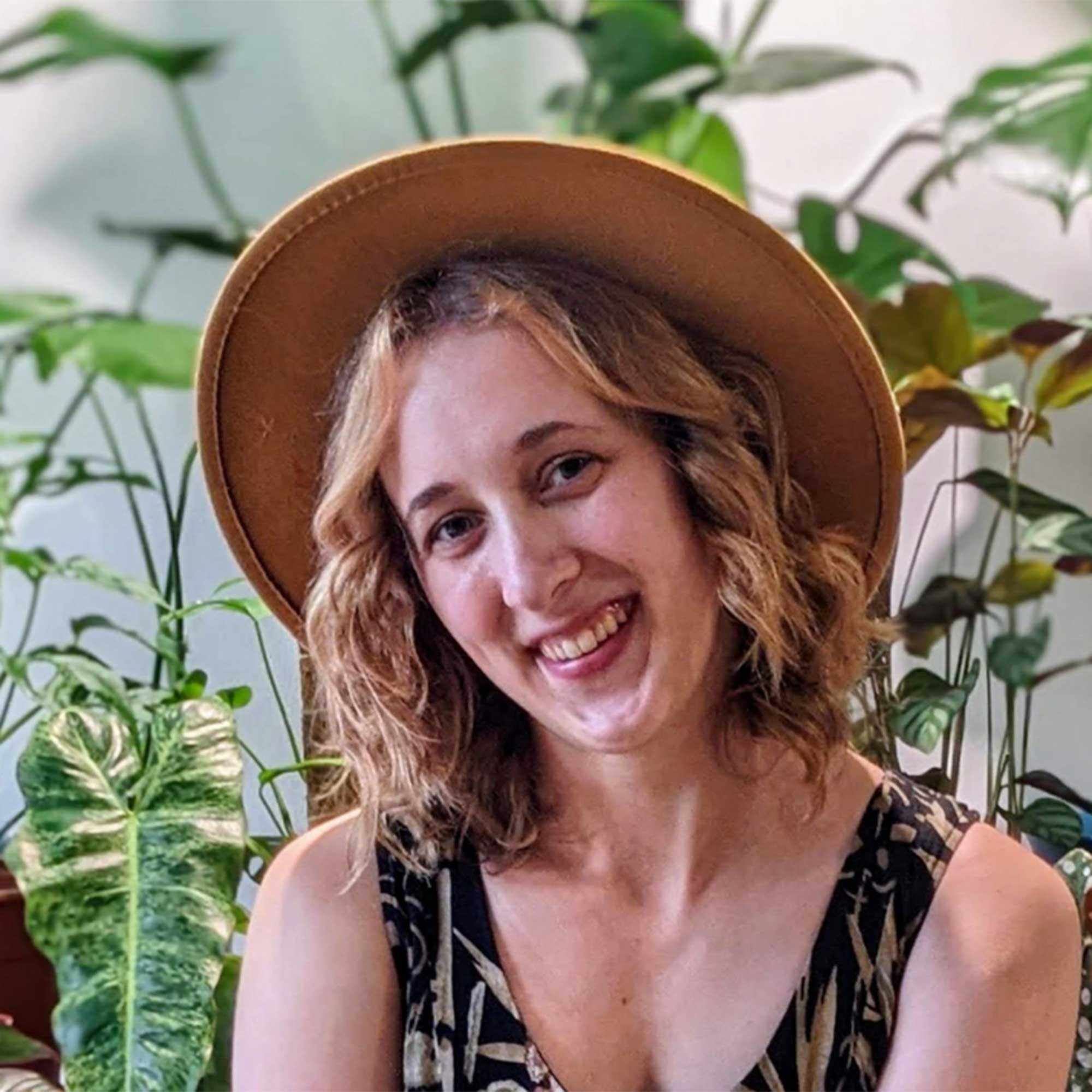 smiling headshot of Kayla Gajdascz, co-founder of Mental Houseplants, wearing a hat