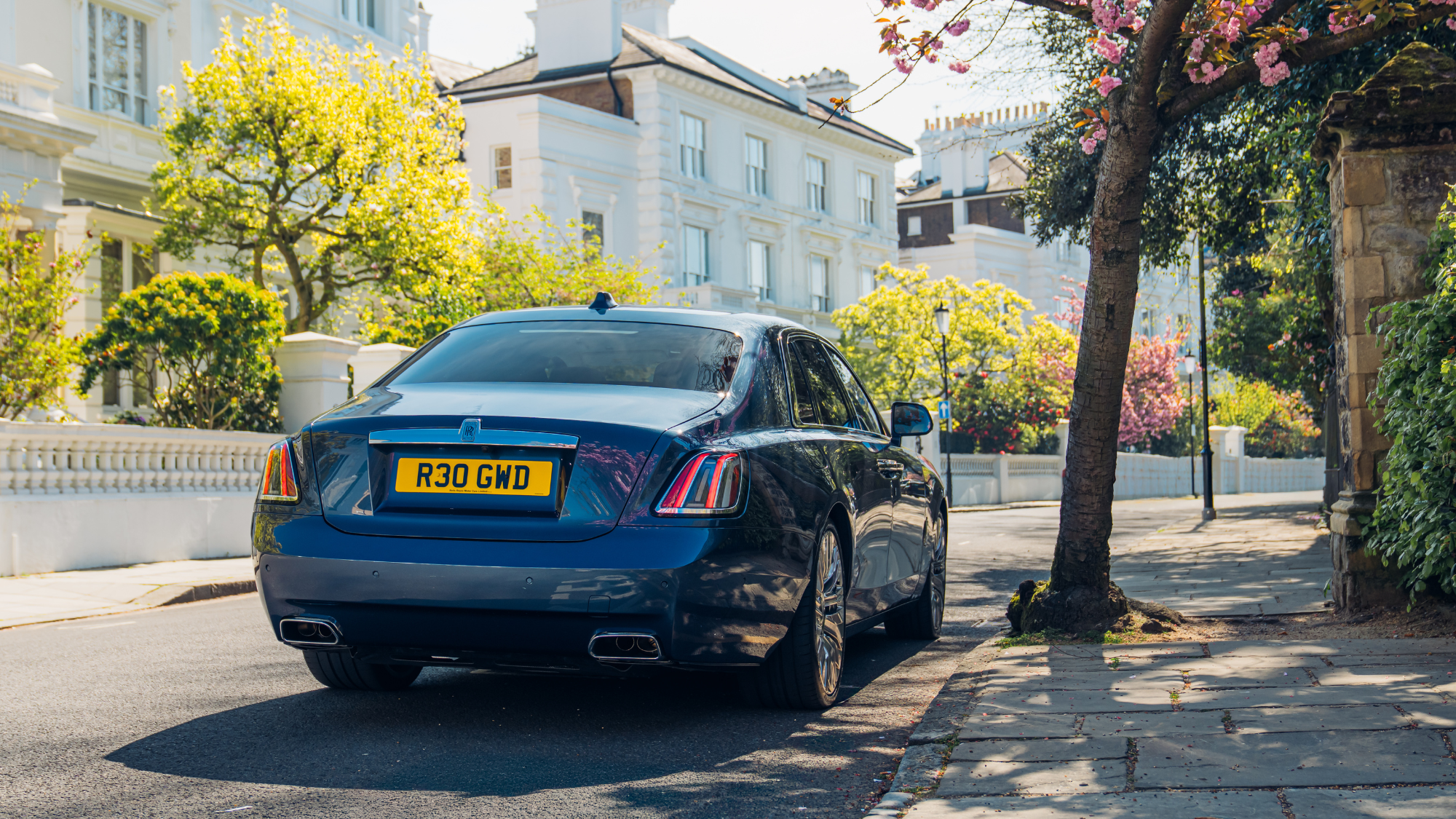 Rolls-Royce Ghost Series II seen from behind on road.