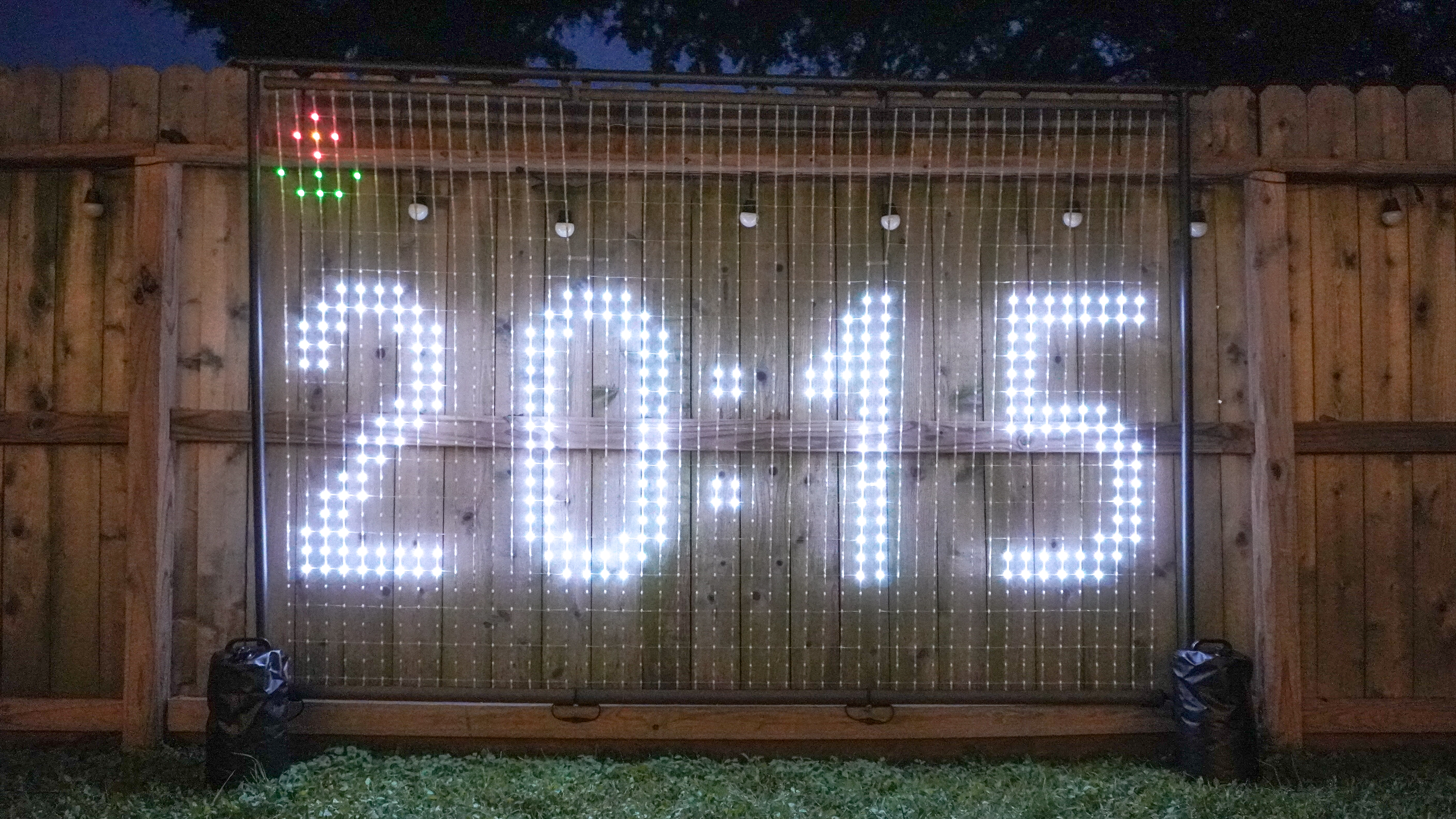 A digital clock displayed on the Govee Lightwall outside in a backyard