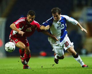 David Thompson of Blackburn Rovers tries to take the ball past Ali Tandogan of Genclerbirligi during the UEFA Cup first round second leg match held on October 15, 2003 at Ewood Park, in Blackburn, England. The match ended in a 1-1 draw, with Genclerbirligi winning the tie 4-2 on aggregate.