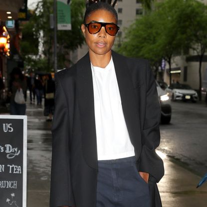 Gabrielle Union wearing a blazer coat, a white tee, and jeans 