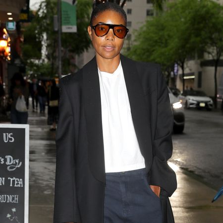 Gabrielle Union wearing a blazer coat, a white tee, and jeans 