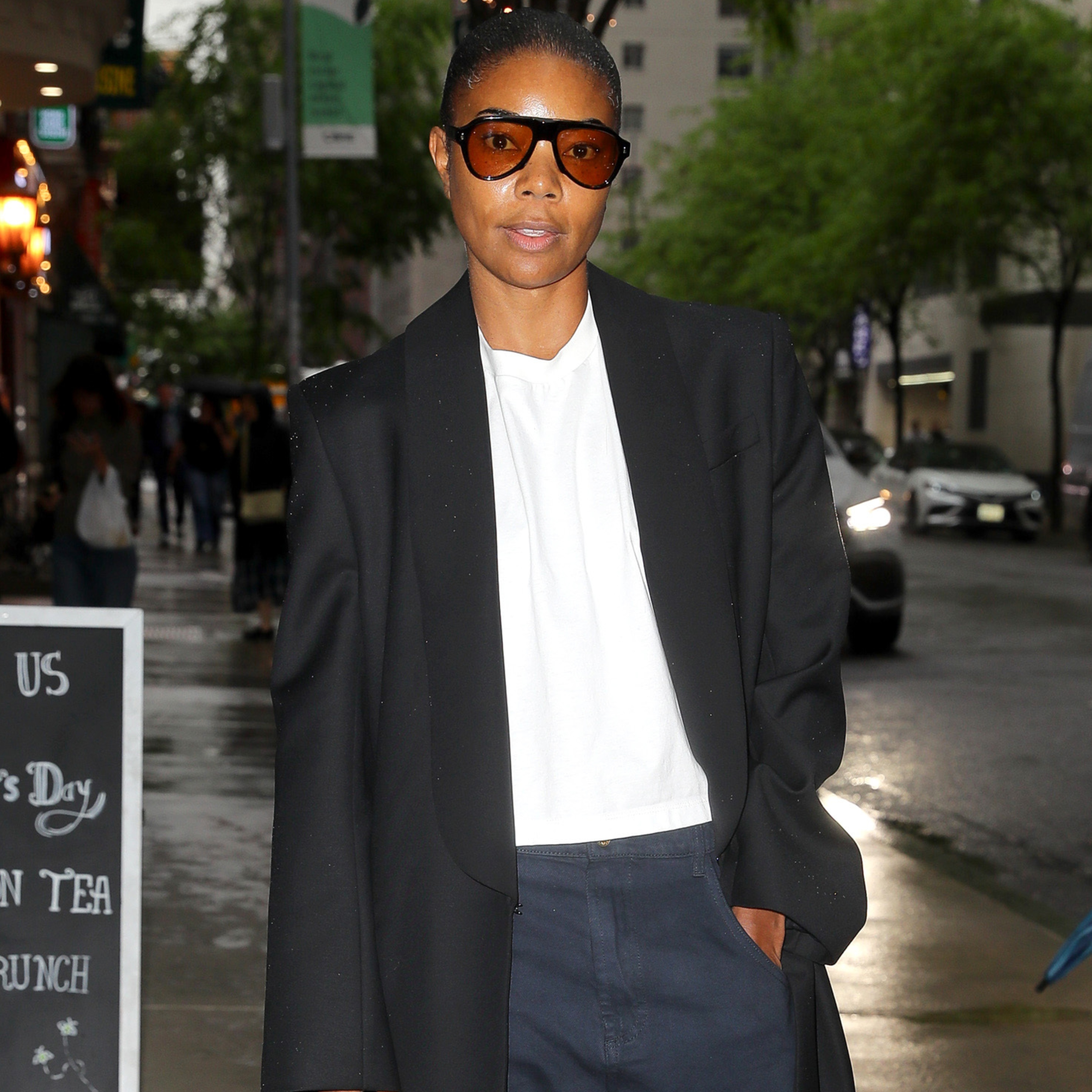 Gabrielle Union wearing a blazer coat, a white tee, and jeans 