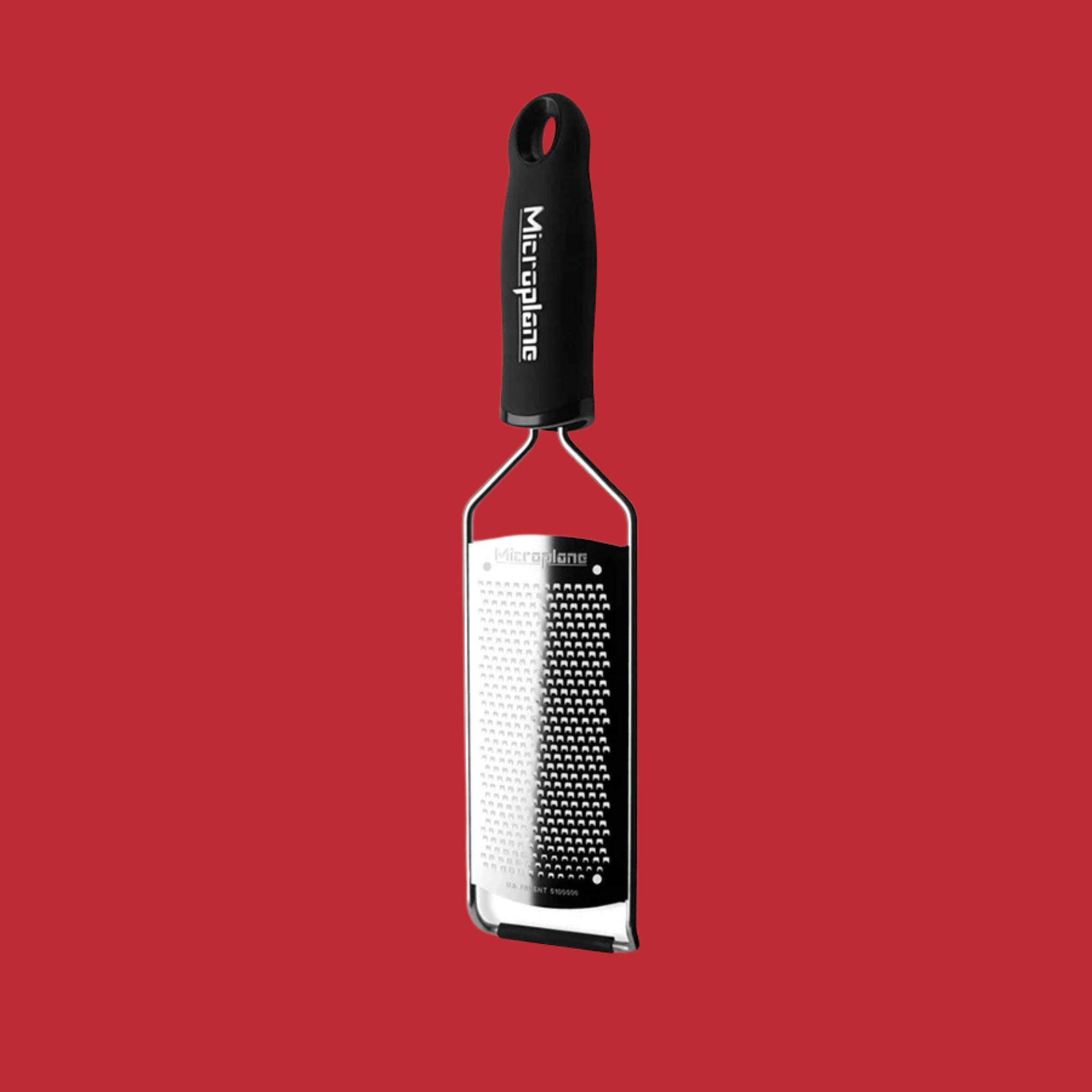 Microplane Gourmet Fine Grater against red background.