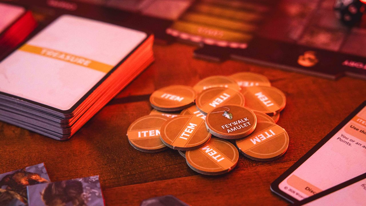 Castle Ravenloft board game components laid out on a dark table, with an ominous red glow on them