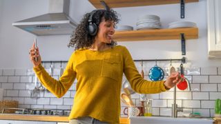 Woman dancing in the kitchen with overhead headphones