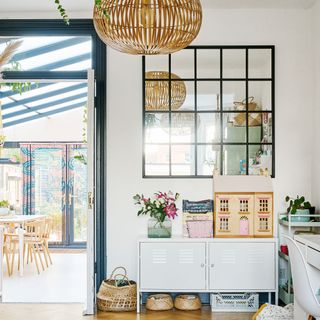 open plan living-kitchen-diner with playroom area full of kids toys and a large grid mirror