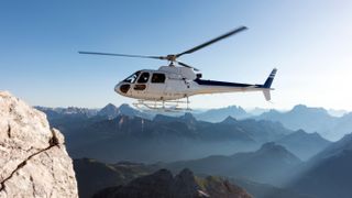 Helicopter flying over mountain range