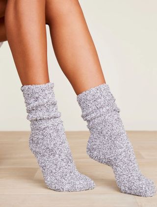 A woman wears a pair of heathered Barefoot Dreams CozyChic socks