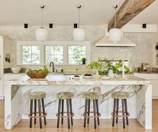 Kitchen with marble island and white glossy backsplash and wooden beams