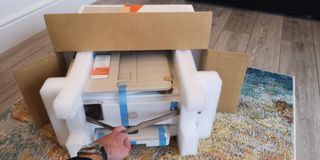 Image shows the HP Envy Inspire being taken out of its packaging.