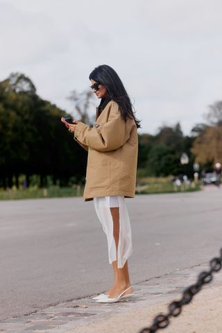 Showgoer wearing a barn jacket during Paris Fashion Week.