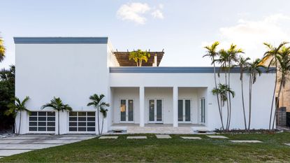 Modern home with white exterior and palm trees