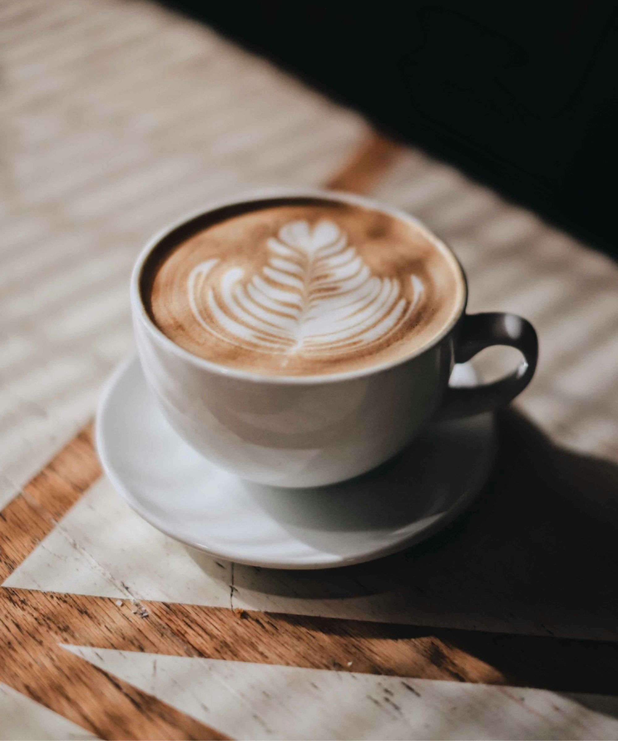 Latte in white mug on wooden table