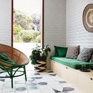 Living room with a wicker basket chair, bench seating and a door open onto a garden