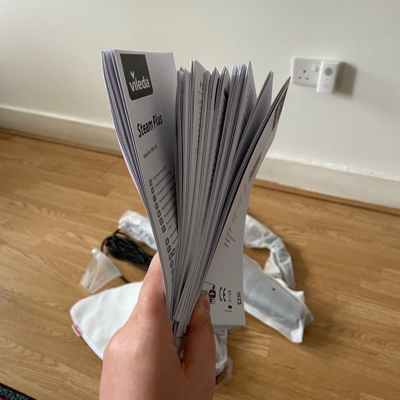 Hand holding a large chunk of instruction manuals