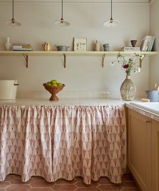 beige painted pantry with cupboad skirt and terracotta floors