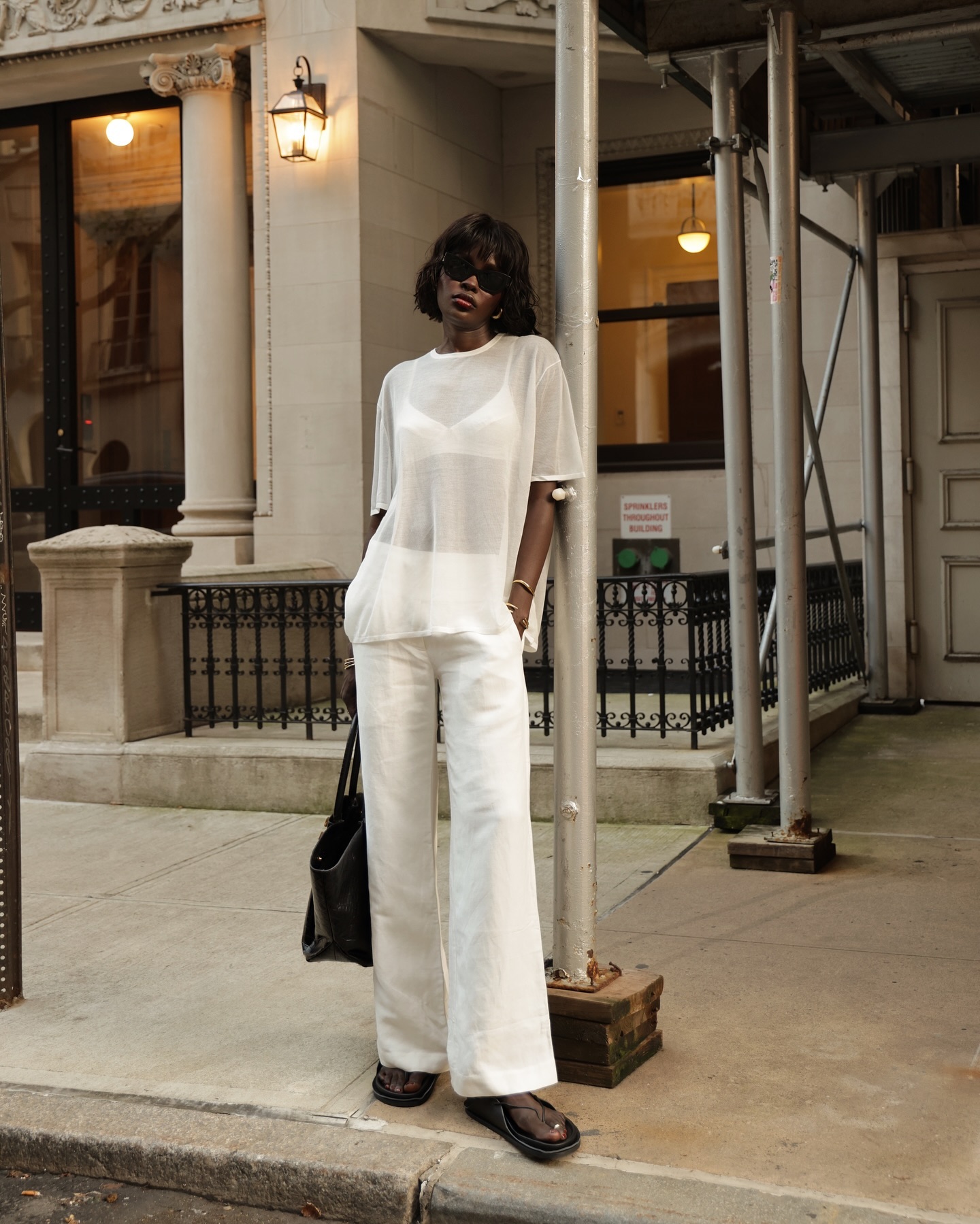 An image of @lefevrediary wearing a fine-knit top with jeans and sandals.