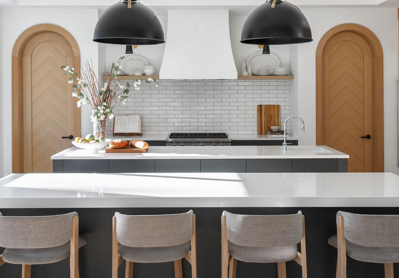 A kitchen with a visual balance in doors, cabinets and lighting pieces