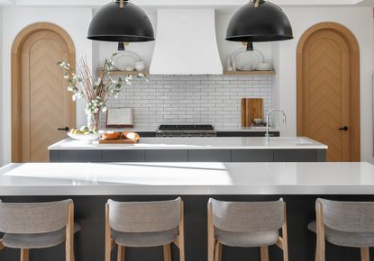 A kitchen with a visual balance in doors, cabinets and lighting pieces