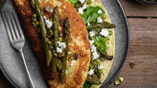 Omelette with asparagus and other green vegetables, folded in half on a plate