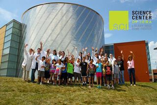 Students and staffers gather outside the Science Center of Iowa in Des Moines. They smile and wave in anticipation of their deep-space portrait session with NASA's Cassini spacecraft during the July 19, 2013,