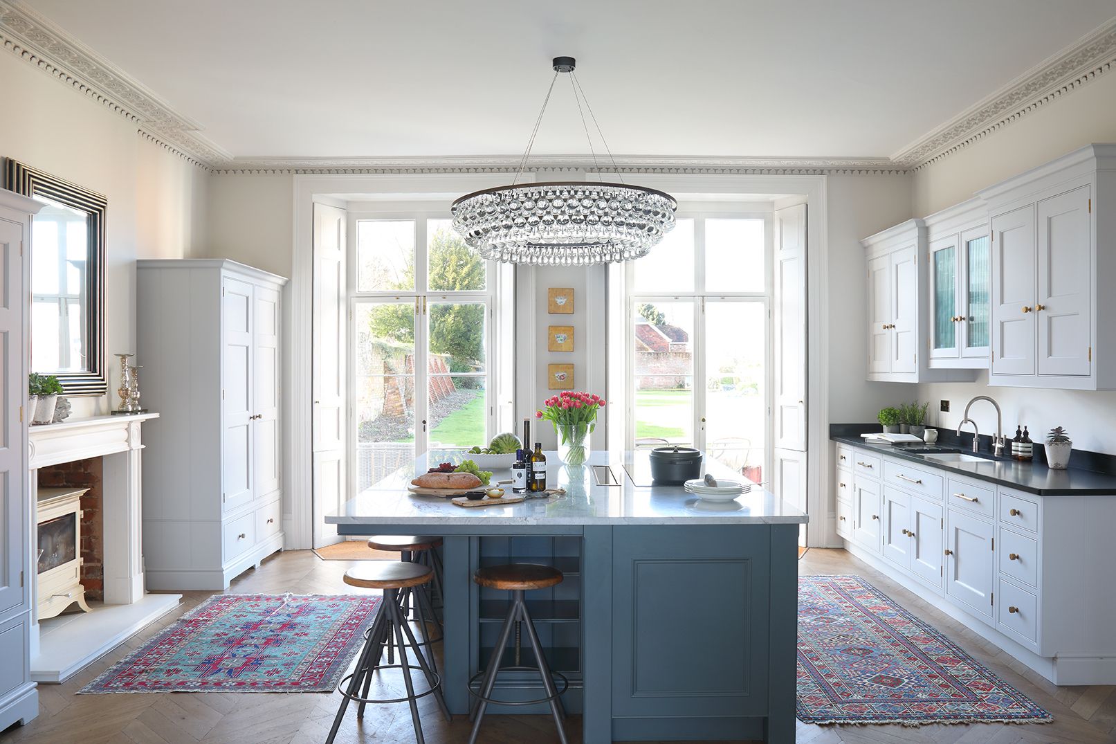 White kitchen with darker island and chandelier above