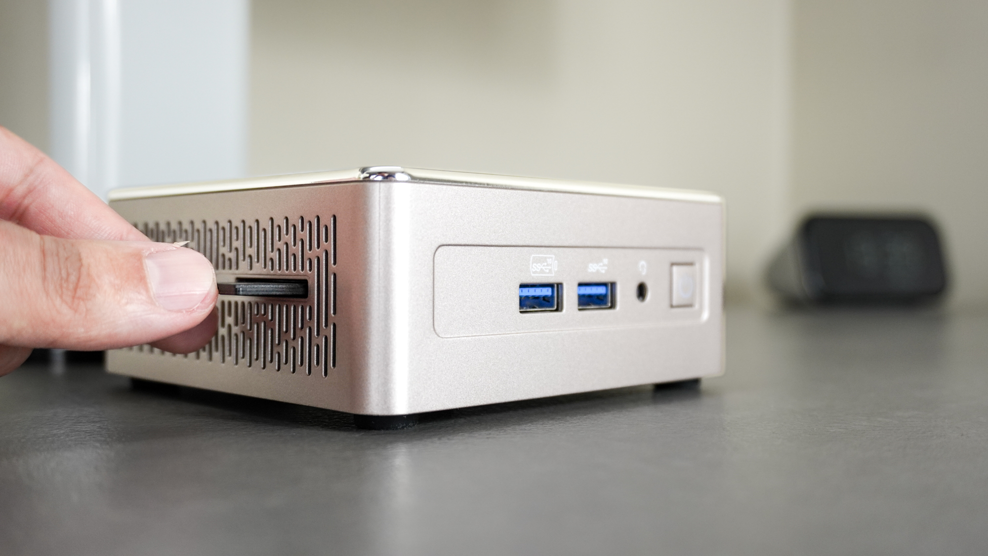A person inserting an SD card into the SD card reader on the side of the Geekom A5 mini PC