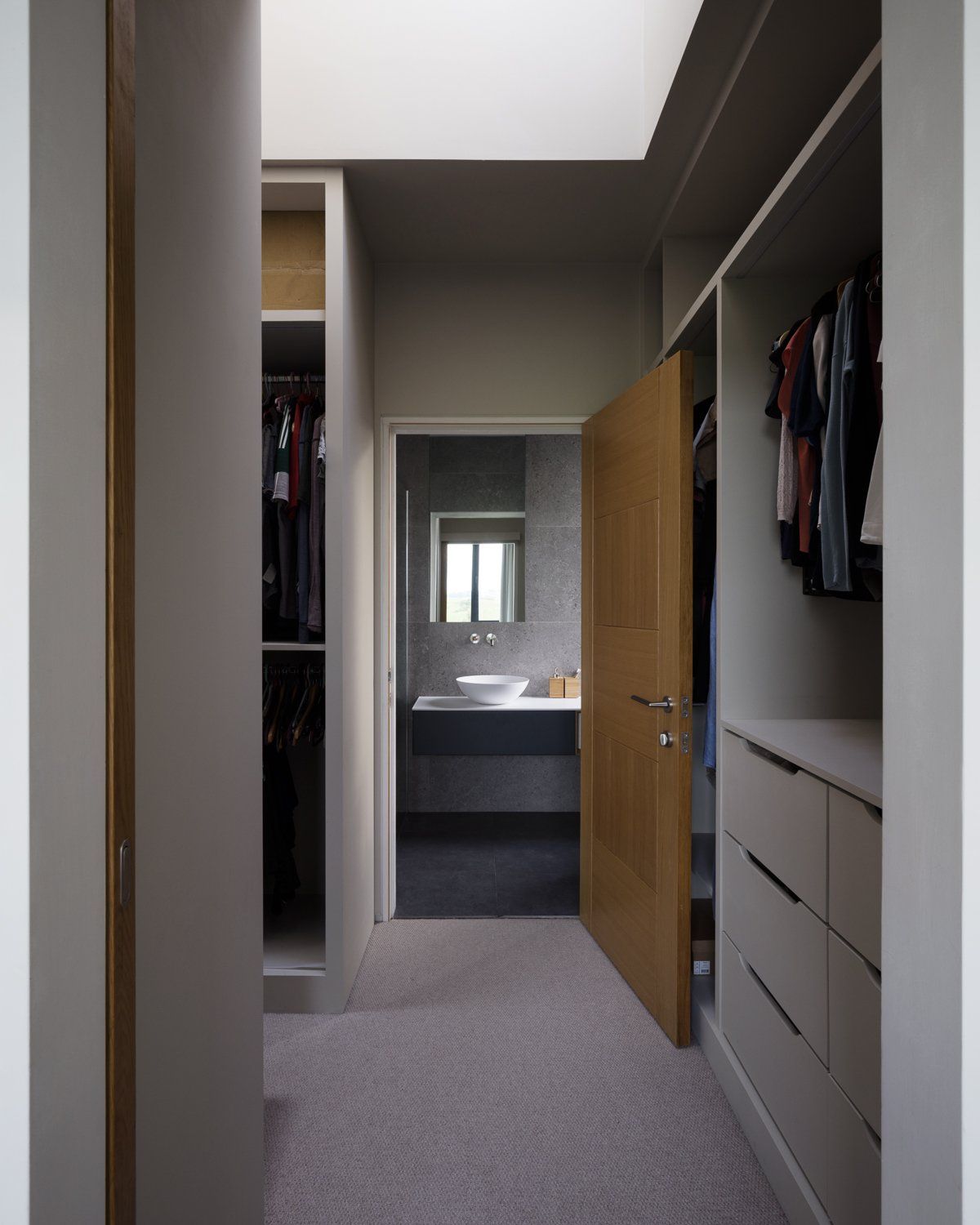 A walk in wardrobe with grey tone walls