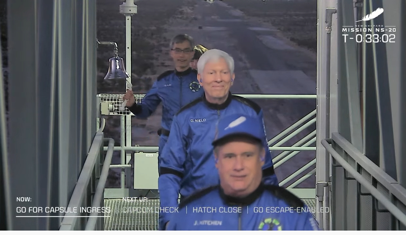 Los pasajeros del Blue Origin NS-20 cruzan el pórtico y tocan una campana ceremonial mientras se preparan para abordar la nave espacial New Shepard.