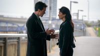 a man and woman talking on a bridge