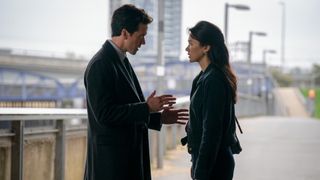 a man and woman talking on a bridge