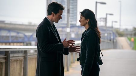 a man and woman talking on a bridge