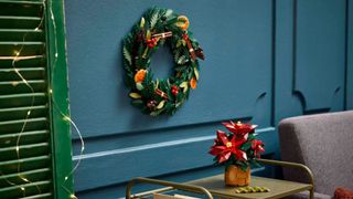 Lego Wreath and Poinsettia laid out on the wall and a table respectively