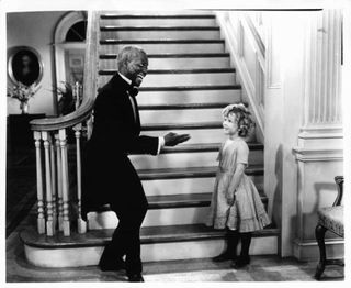 Young Shirley Temple dancing with man in tux, black & white still