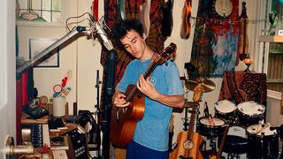 Jacob Collier playing his five-string Taylor acoustic