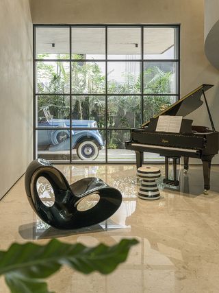 inside House of Gardens by Kanan Modi with a car outside the window