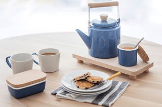 Table with teapot and cookies in plate