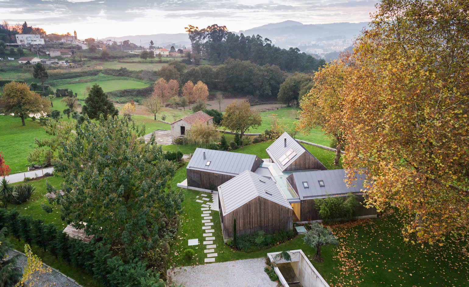 A vacation home for a family of four, the house is formed by four separate structures united by a glazed central core