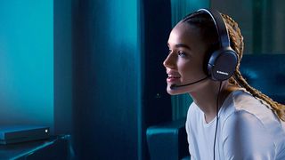A woman using a pair of SteelSeries Arctis 1 gaming headphones