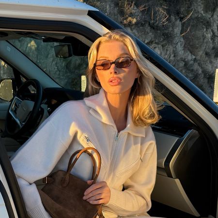 Elsa Hosk wearing crew sweaters, white leggings, and The Row bag and shoes