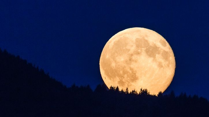 Supermoon glowing against blue sky