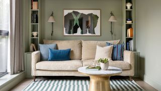green living room with art print and beige sofa