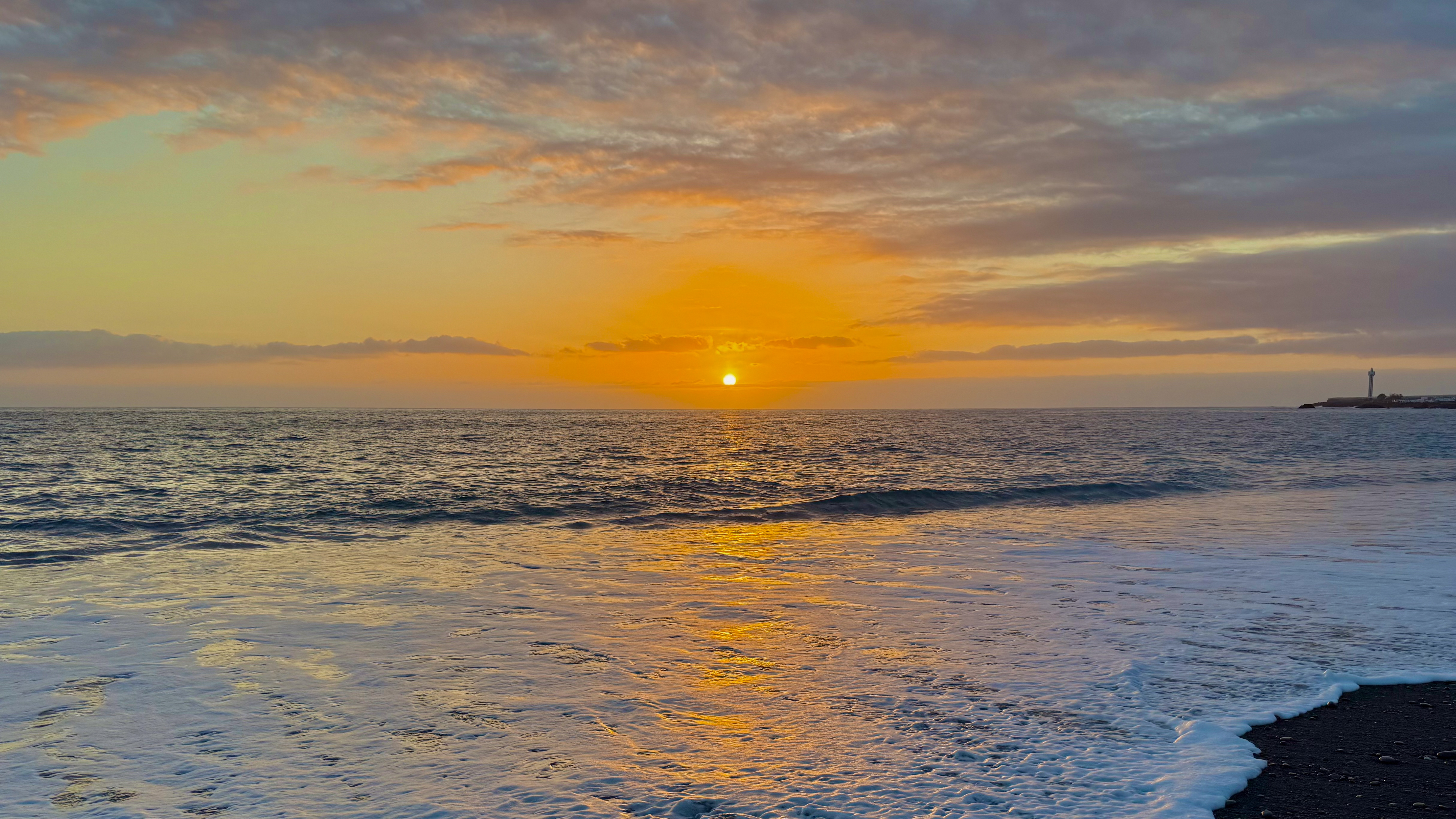 a vivid orange sunset over the ocean.