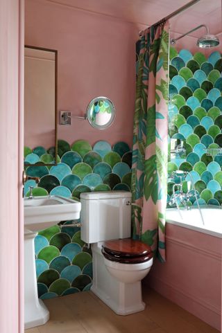Kids' bathroom with bright pink walls and green tiles